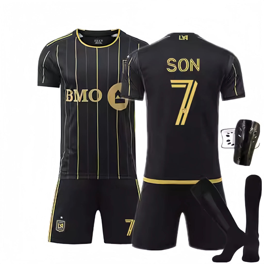 Black sports jersey with gold accents, shorts, socks, and shin guards on a white background.