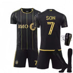 Black sports jersey with gold accents, shorts, socks, and shin guards on a white background.